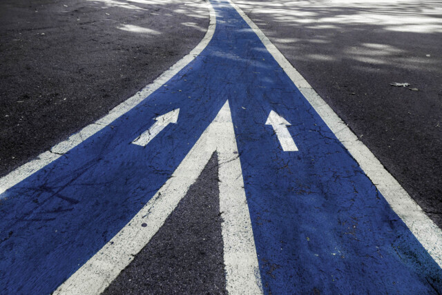 Two blue lanes, on a road, merging to visualise mergers and acquisitions